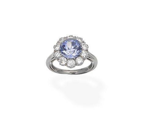 A sapphire and diamond cluster ringThe circular-cut sapphire within a surround of brilliant-cut diamonds, diamonds approx. 1.