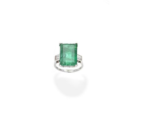 An emerald and diamond ringThe step-cut emerald between baguette-cut diamond shoulders, diamonds approx. 0.40ct total, ring s