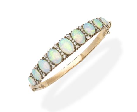 An opal and diamond bangle, circa 1890Of hinged design, set to the front with a graduation of oval opal cabochons, accented b