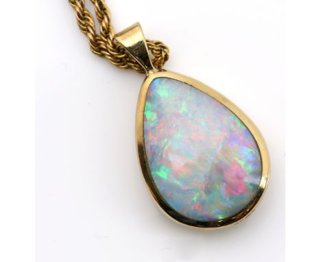 Contemporary double sided opal pendant, pear cabochon cut opal, rub over set in yellow gold, measuring approximately 3 x 1.6c