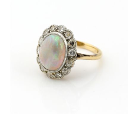 Opal and diamond cluster ring, oval cabochon cut stone  estimated weight 2.12 carats, set within a frame of old cut and Swiss