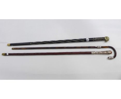 Three walking sticks to include two with white metal mounts and one with a skull handle and bone inlay (3) 