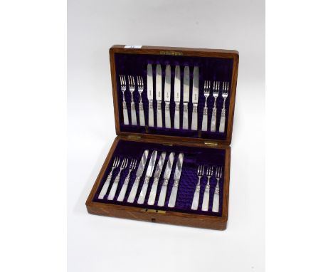 An Edwardian oak canteen of silver and mother of pearl fruit knives and forks, 12 place setting but lacking one knife, Sheffi