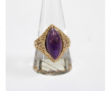 A vintage 9ct gold ring with a amethyst cabochon in a floral engraved setting, London 1973