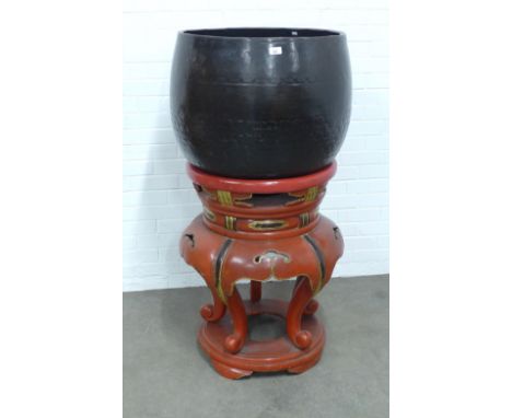 A Buddhist bronze temple gong on a red lacquer and gilt decorated stand, on four scroll feet, 70 x 132cm.