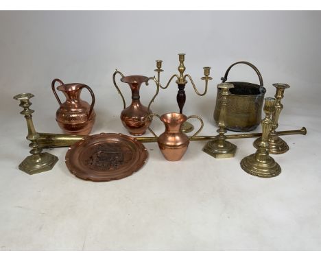 A collection of copper and brass items to include four candlesticks and a candelabra, vases, a inlaid plate, a hunting horn a