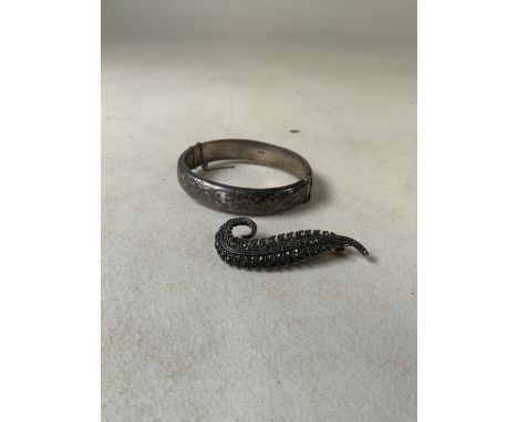 A sterling silver bangle together with a silver marcasite set feather brooch. 1.1oz.