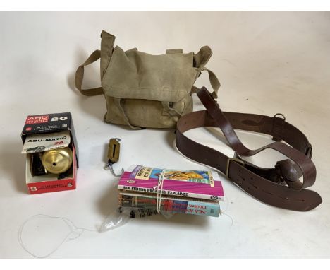 A collection of fishing items including a Swedish Abu Magic casting reel, a weighing scale, books, leather belt and a bag