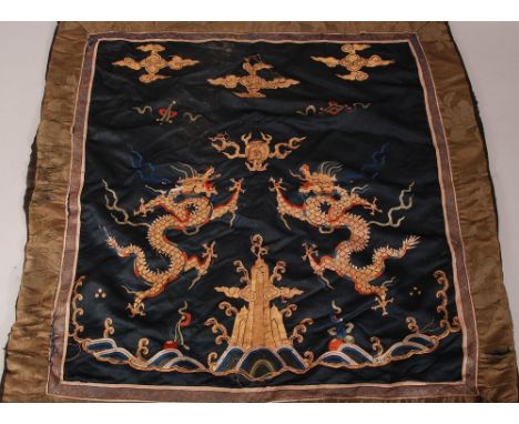 C17th Chinese silk embroidered panel, woven with two dragons chasing a flaming pearl above crashing waves, 69 x 73cm. 