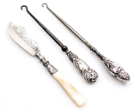 A Victorian silver butter knife, with mother of pearl handle, Birmingham 1862, and two silver handled button hooks.  (3)