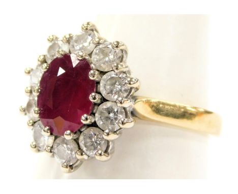 An 18ct gold ruby and diamond ring, the oval cut ruby in a surround of ten diamonds, ruby approximately 0.9 carats, diamonds 