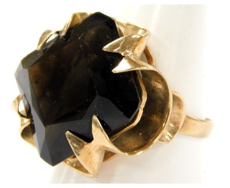 A 9ct gold and smoky quartz ring, the square cut stone in a scrolling claw setting, approximately 7.5 carats, size S/T, 10.0g