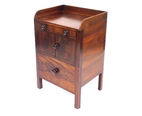 A late Georgian mahogany commode, with a long drawer over a pair of cupboard doors, the pull out base with ceramic bucket and