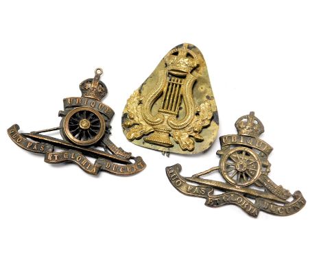 Two Royal Artillery cap badges, together with an army bandsman's cap badge.  (3)