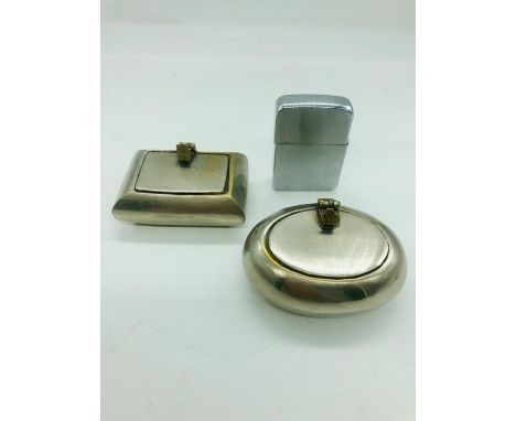 Two white metal pocket sized ashtrays and a Zippo lighter 
