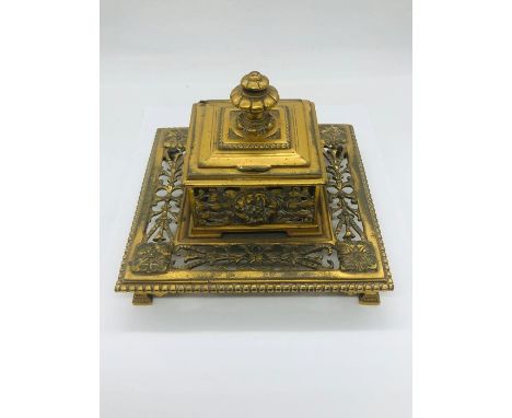 A brass inkwell with glass liner