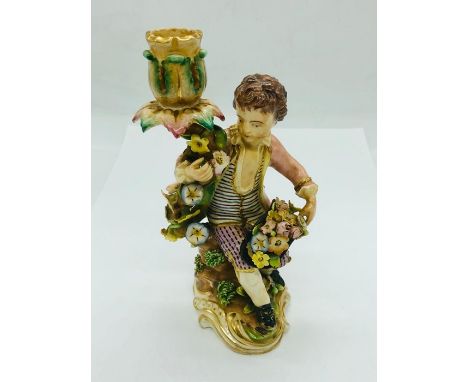 An 18th Century Meissen Candlestick in the form of a boy with a floral theme.