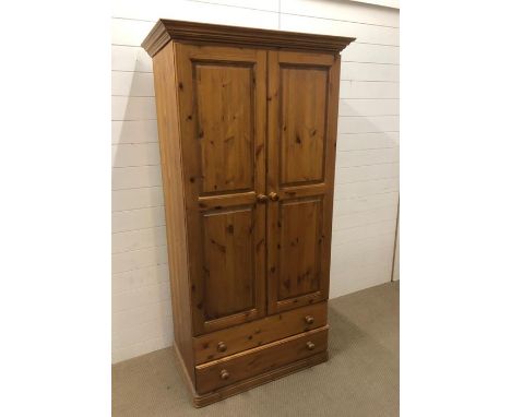 A modern pine wardrobe with hanging shelf and two lower drawers 