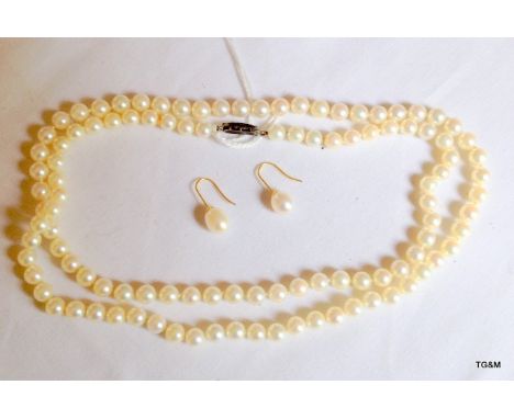 A ladies pearl necklace with silver clasp and a pair of ladies pearl earrings