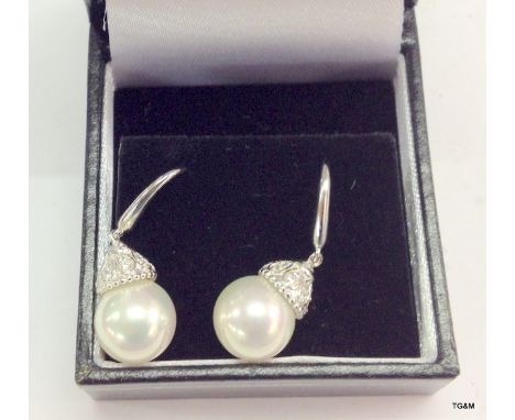 A pair of silver freshwater pearl and cz earrings