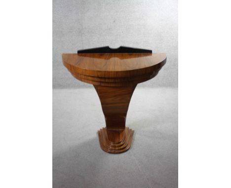 An Art Deco style figured walnut and ebonised demi lune console table with shaped support on stepped base. H.85 W.98 D.47 cm 