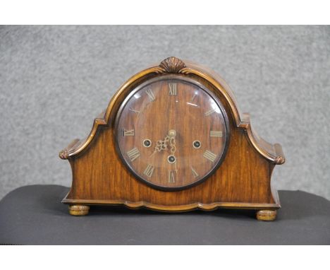 A mahogany veneered Wellington style quarter chiming mantle clock with brass movement and Roman numerals. With key.  H. 25 W.