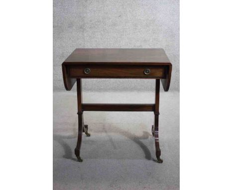 A small Regency style mahogany and ebony strung sofa table on swept supports resting on brass cup casters. H.73 X W.69 (openi