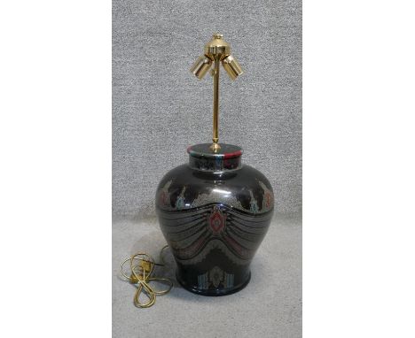 A large Eastern colourful transfer design black ceramic table lamp with brass double bulb fitting. H.77 D.34 