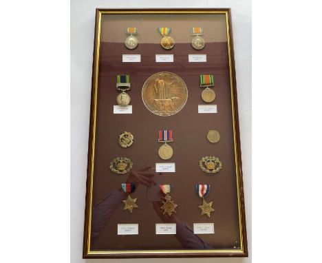 AN APPARENT FAMILY GROUP OF FIRST AND SECOND WORLD WAR MEDALS. A framed collection of medals, badges and a memorial plaque to