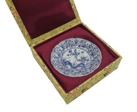 Chinese blue and white cafe au lait small circular saucer, the centre decorated with flowers and rockwork within a repeating 