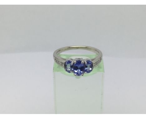 A 14ct white gold ring set with three tanzanite stones and eight small diamonds, approx 3g and approx size M.