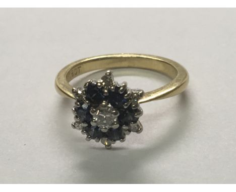 An 18carat gold ring set with a pattern of diamonds and blue Sapphire. Ring size K.