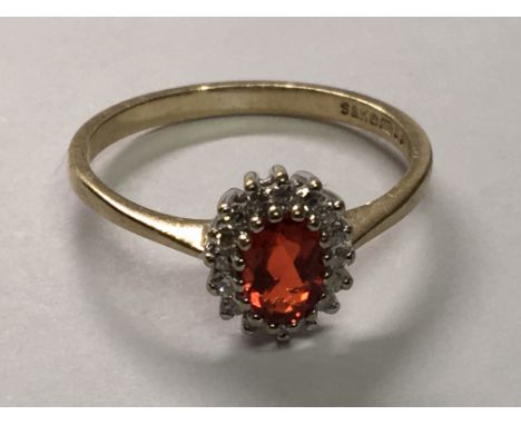 A 9carat gold ring inset with a red fire opal and small diamonds ring size N.