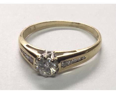 An 18carat gold ring set with a brilliant cut diamond approximately 0.33 of a carat flanked by graduating smaller stones. rin