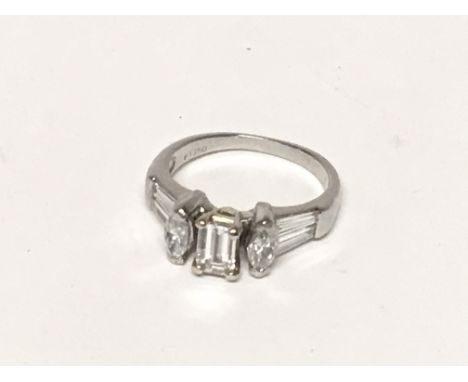 A Quality modern design and pretty platinum engagement ring set with a pattern of baguette Marquise and a central Emerald cut