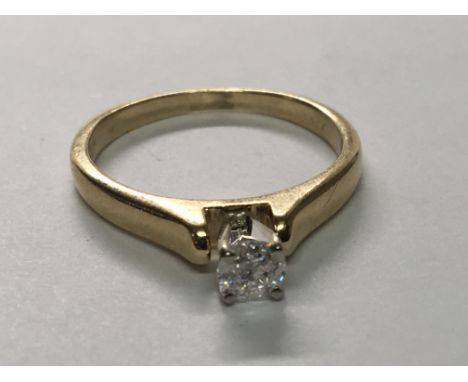 A 10 carat yellow gold ring set with a solitaire brilliant cut diamond. Ring size M.