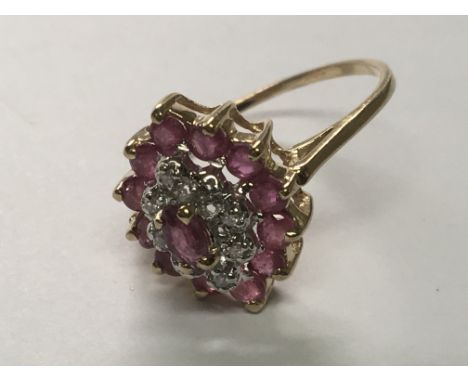 A 9carat gold ruby and diamond cluster ring. Ring Size N.