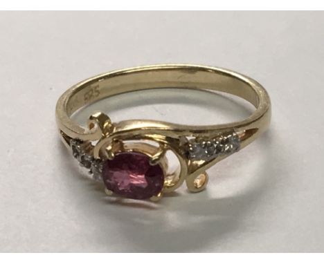 A 14carat gold ring set with a ruby coloured stone possible heat treated set with small diamonds. Ring size J.