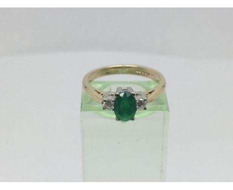 A 9ct gold ring set with a central green stone with a diamond to either side, approx 3g and approx size M-N.