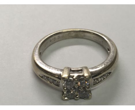 A 18 carat gold ring set with a pattern of diamonds with diamonds set in the shank ring size K.