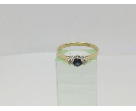 An 18ct gold ring set with a central sapphire and two diamonds, approx 2.3g and approx size R-S.