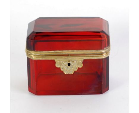 TWENTIETH CENTURY RUBY GLASS AND GILT METAL MOUNTED CASKET of canted oblong form, 4" (10.2cm) high, 4 3/4"  x 3" (12cm x 7.7c