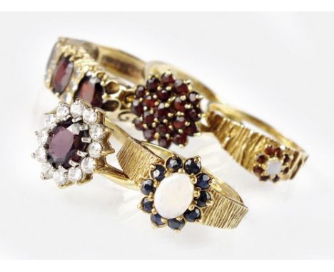 A 9ct gold opal and sapphire dress ring, together with a 9ct gold opal and garnet dress ring, a garnet cluster ring and two 9