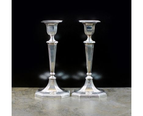 A pair of Victorian silver candlesticks, William Hutton & Sons Ltd, London 1900, each designed as a reeded tapering column su