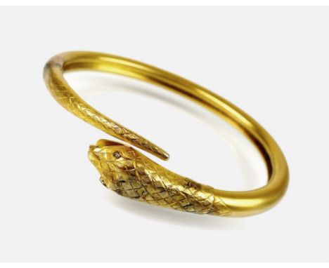 A late 19th century stylised snake bangle, the yellow metal snake with engraved 'scales' and diamond set eyes, not stamped, w