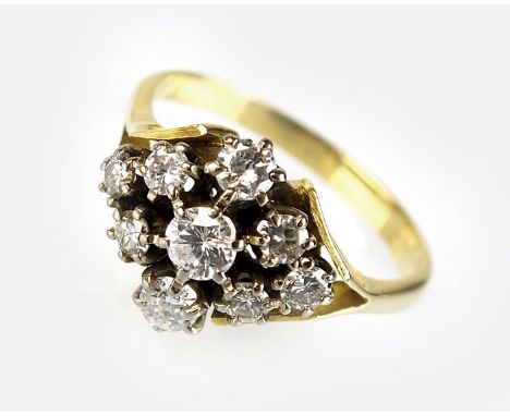 A nine stone diamond cluster ring, designed as a central brilliant cut diamond within a surround of eight graduated diamonds,