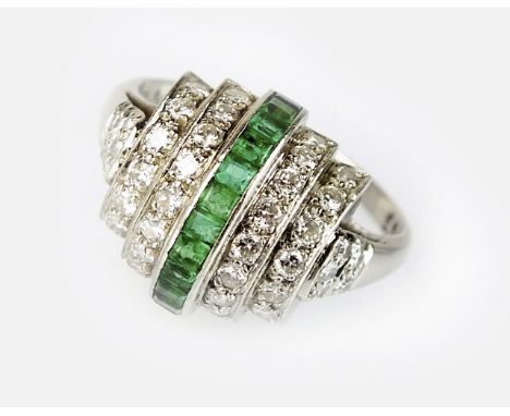 An Art Deco emerald and diamond dress ring, designed as a central domed row of channel set square cut emeralds, flanked to ea