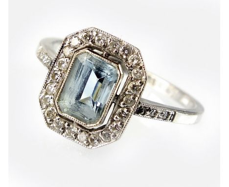 An Art Deco style aquamarine and diamond cluster ring, designed as a central emerald cut aquamarine collet set in white metal