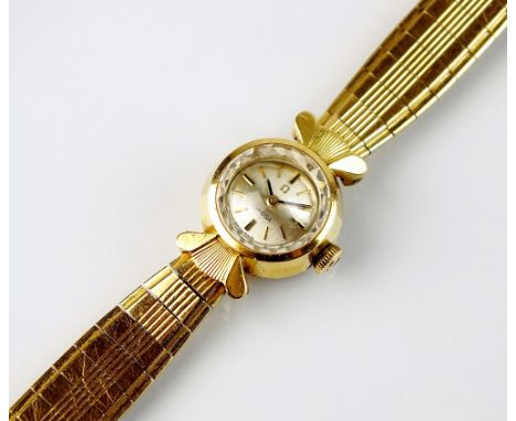 A Lady's 18ct gold Omega bracelet wristwatch, the circular silvered dial with batons, manual wind, engraved monogram to the b