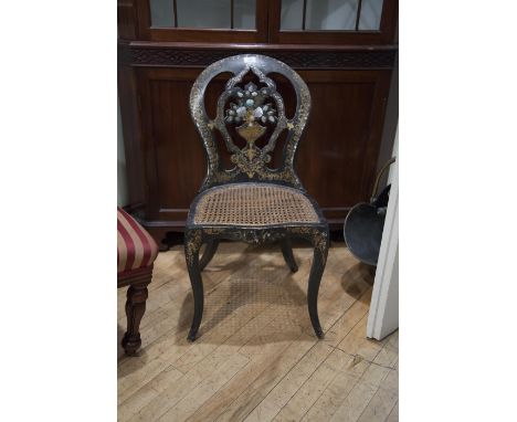 A VICTORIAN BLACK PAPIER MACHÉ SALON CHAIR with inlaid mother of pearl and gilded decoration, having a cane seat and raised o